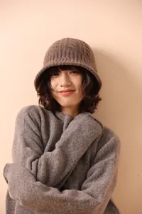 Detail of dark coffee merino wool knit bucket hat featuring thick cable knit texture