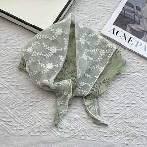 Detailed texture of light green floral cotton linen scarf with elegant lace embroidery