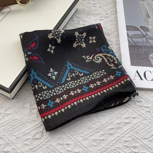Detail of vintage paisley pattern on black cotton linen scarf with red geometric border