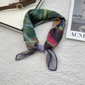 Detailed view of floral printed silk scarf with fine blue hand-rolled stitched edges