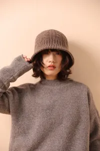 Close-up of cable-knit texture on a 100% merino wool brown bucket hat with grey sweater