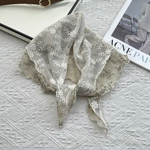 Detail view of double-layer lace and floral cotton neckerchief with scalloped edges