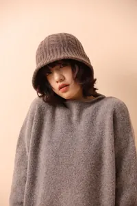 Detailed knit texture of 100% Merino wool bucket hat and matching brown sweater