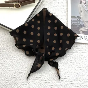 Detail of cotton neckerchief featuring a brown cross pattern with knotted styling