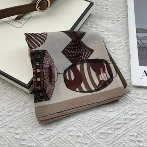 Detailed shot of vintage paisley square scarf on white gift box with silk texture