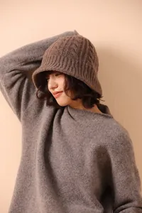 Detail of dark brown cable knit merino wool bucket hat worn by model for winter