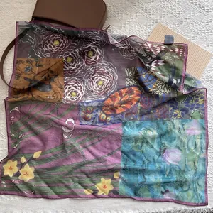 Detail of floral and geometric print silk scarf featuring camellia and bird patterns