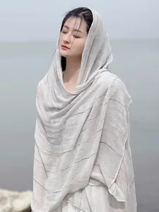 Detail of soft linen scarf with subtle horizontal stripes and natural frayed edge texture