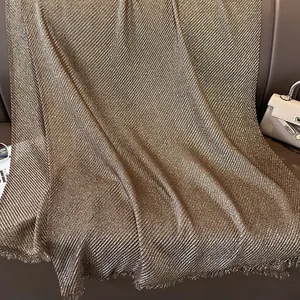 Golden shimmering cotton linen scarf with vertical pleats and fine fringe details