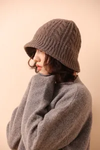 Detailed close-up showing the chunky cable knit texture of the wool bucket hat in mocha