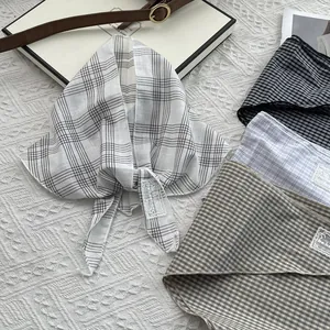 Detailed view of four plaid triangle scarves with embroidered be keen on labels