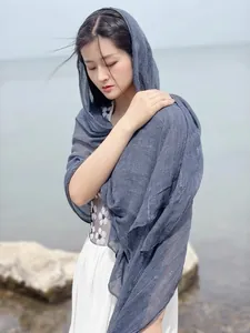 Detail of grey-blue linen scarf featuring fine pleated texture on a soft cotton fabric