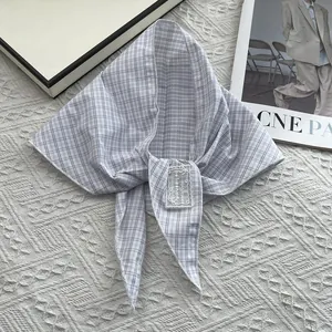 Detail of grey checkered cotton triangle scarf featuring a lace embroidery patch