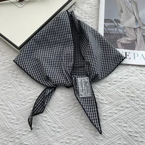 Detail of checkered cotton scarf showing fine stitching and premium fabric texture