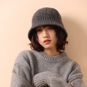 Deep grey merino wool cable knit bucket hat worn by model for cozy winter style