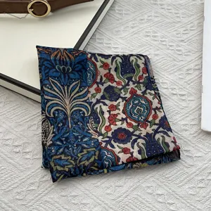 Close-up of vintage floral print silk scarf with deep blue and beige ethnic patterns