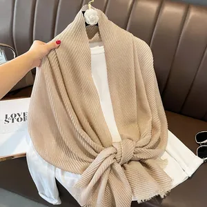 Close-up of champagne pleated scarf with fine gold sparkles and natural raw edges