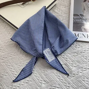 Detailed close-up of blue and white checkered cotton neckerchief with lace label on fabric