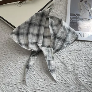 Detail of pure cotton plaid triangle scarf with 'be keen on' label and textured edge