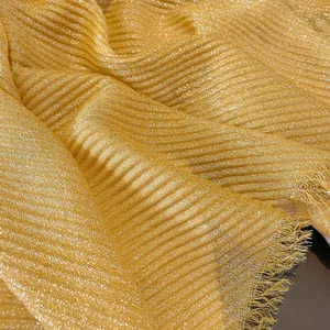 Close-up of gold pleated linen scarf with metallic shimmering threads and fringe edges