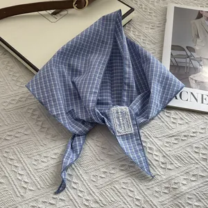 Detailed close-up of a blue and white checkered cotton bandana with white lace patch decor