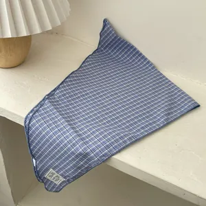 Detail of blue and white checkered cotton scarf showing edge stitching and fabric tag