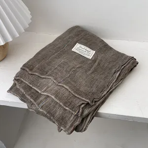 Detail of dark brown knit cotton linen scarf with ribbed texture and woven label
