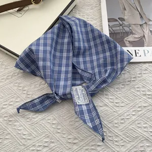 Detail of blue and white checkered cotton scarf with vintage lace brand label