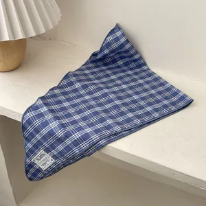 Detail of blue plaid cotton bandana with fine stitched edges and premium woven brand label