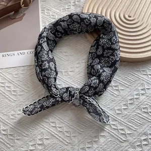 Detail of black and white paisley silk scarf tied in a knot showing fabric texture