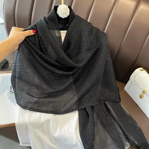 Detail of black pleated cotton linen shawl featuring delicate gold glitter shimmer finish