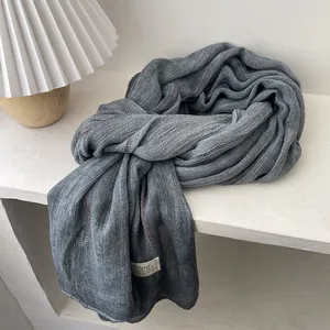 Detail of dark grey cotton linen scarf with red contrast stitching and mesh texture