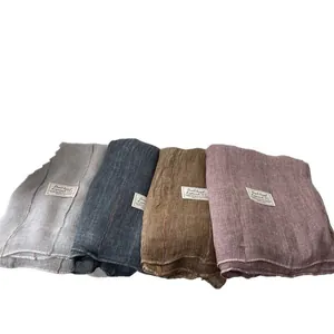 Stack of four textured cotton linen scarves in grey, navy, brown, and pink tones