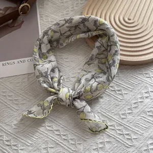 Detail of floral silk scarf with lemon print and yellow wavy stitched edges