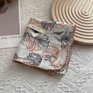 Detail of floral cotton linen scarf with crochet lace trim and explore infinity tag