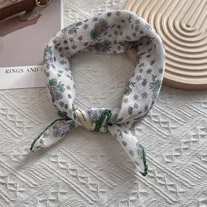 Close-up of small floral scarf with green stitched edges and Love infinity label