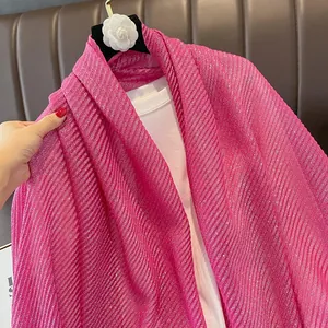 Detail of rose red pleated shawl with metallic glitter and fine vertical texture