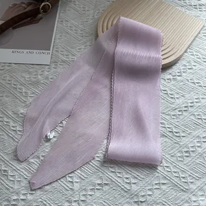 Detailansicht der rosa plissierten Seidenschal-Textur auf weißer Spitze