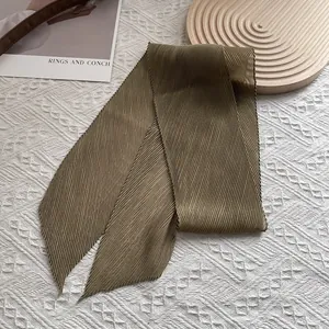 Detail eines olivgrünen Plissee-Schals mit eleganten Falten und spitzen Enden