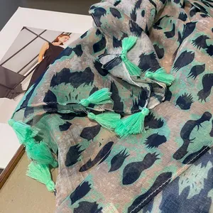 Detail of green leopard print scarf with soft tassels and premium bali yarn texture