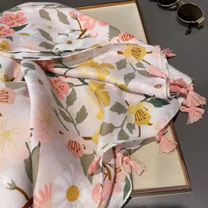 Detailed view of floral pink beach scarf with decorative tassels and lightweight fabric