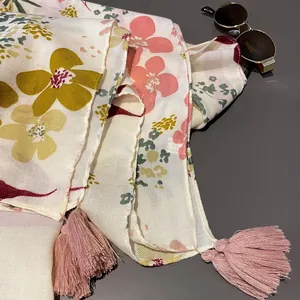 Detailed shot of ethnic style floral scarf with tassels and soft twill fabric texture