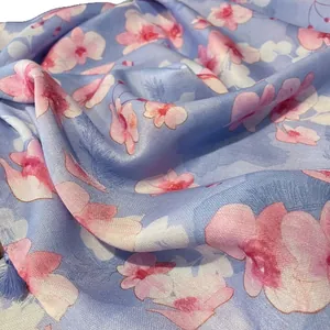 Écharpe florale rose en coton et lin sur fond bleu clair pour la protection solaire d'été