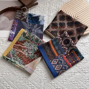Flat lay of four vintage patterned silk square scarves with floral and geometric designs