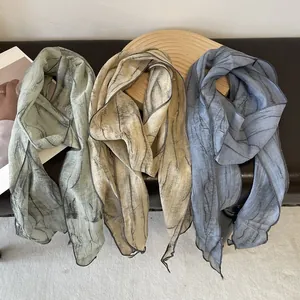 Tie-dye striped thin silk scarves in light green, beige, and blue with pleated texture