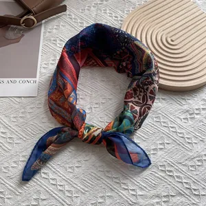 Bohemian geometric print silk scarf displayed with leather bag and magazine on white fabric
