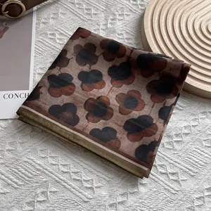 Detail of vintage brown floral silk scarf on a textured knit blanket with aesthetic props