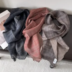 Primer plano de bufandas ligeras de lino a cuadros en azul marino, rojo coral y taupe