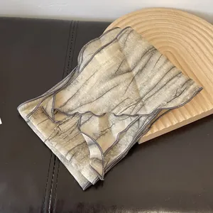 Macro detail of tie-dye striped scarf showing natural wood texture and gray stitched edges