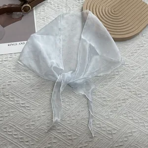 Détail d'un foulard en mousseline fleurie montrant la texture légère et translucide